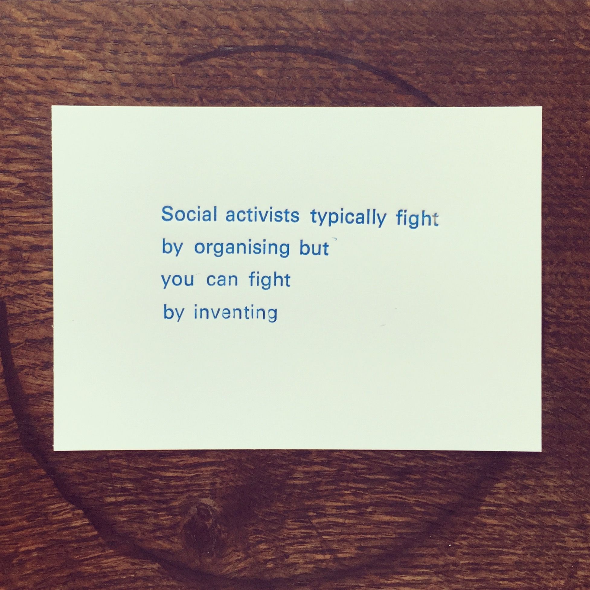 A quote by Bret Victor that says, social activists typically fight by organising but you can fight by inventing, letter-pressed in blue ink on a white postcard